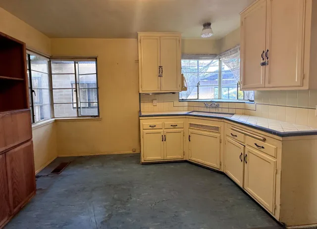 a kitchen with white cabinets and white appliances