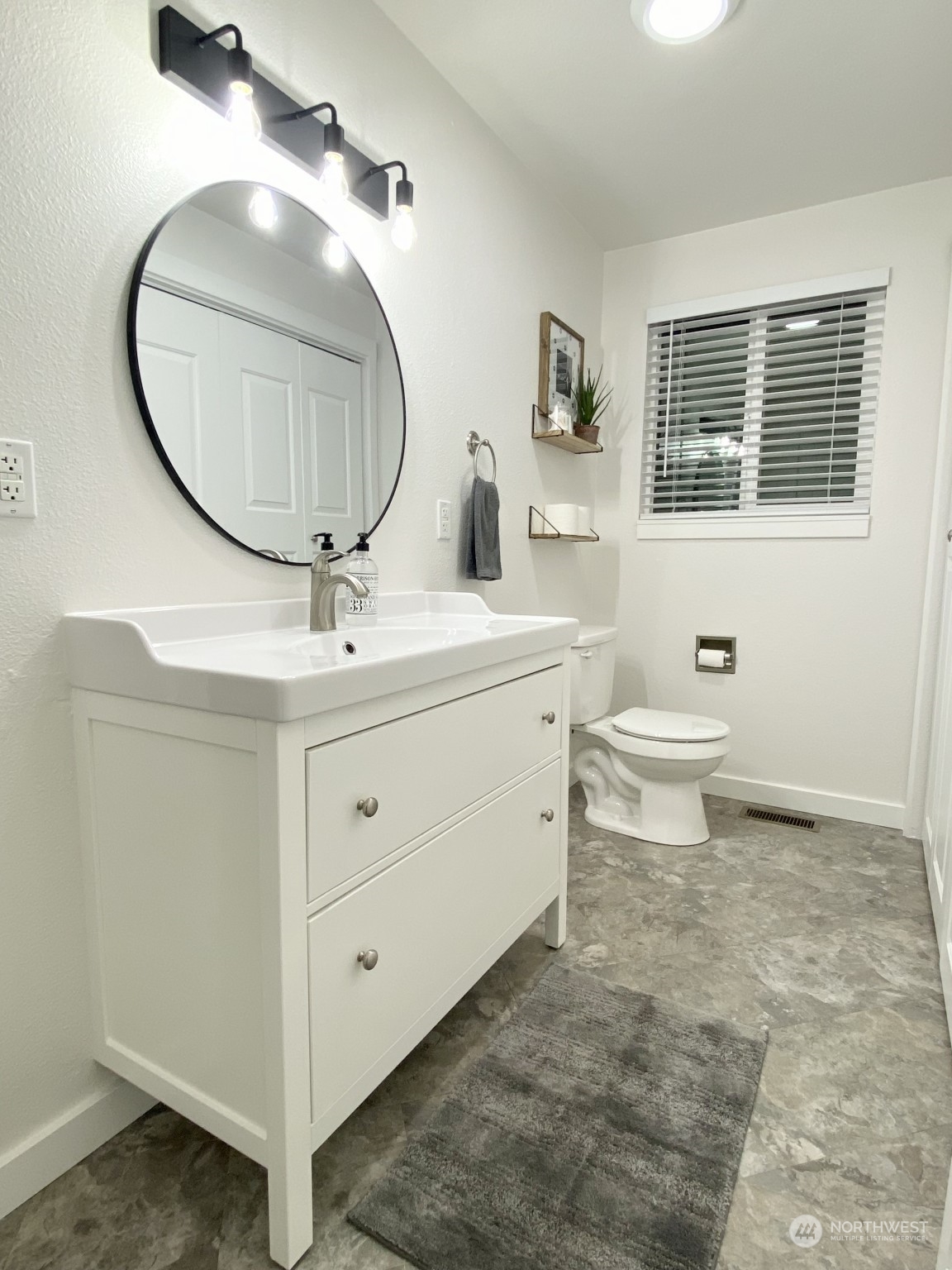 304 South Cleveland Street Kennewick, WA 99336 - Photo 10 of 12 a bathroom with a toilet a sink a mirror and a bathtub