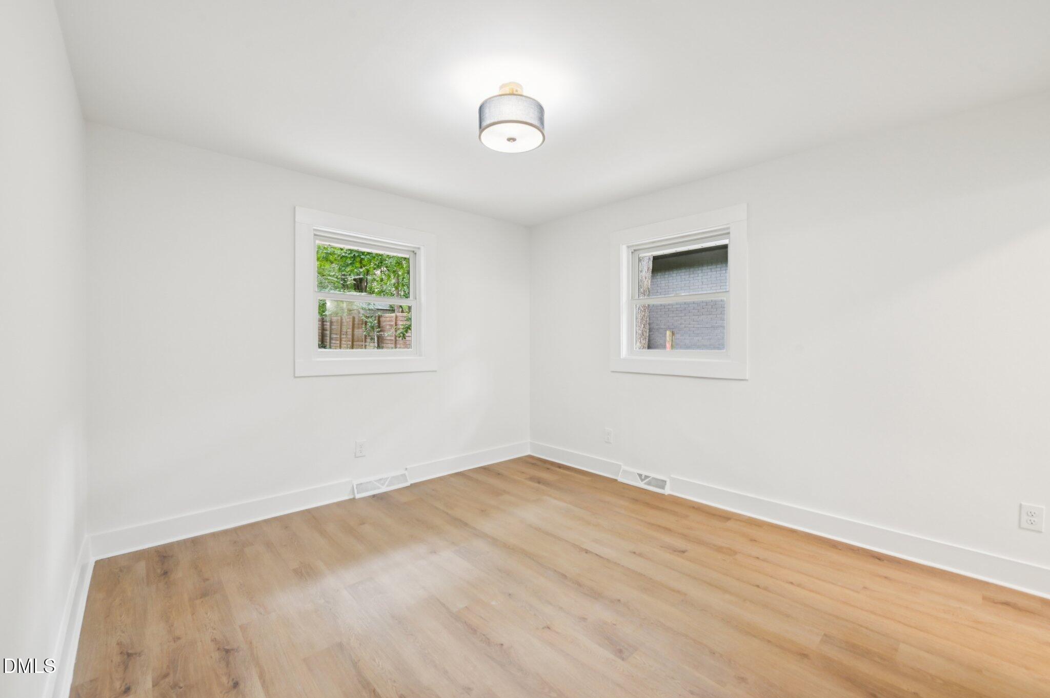 2708 Sarah Avenue Durham, NC 27707 - Photo 13 of 31 an empty room with wooden floor and windows