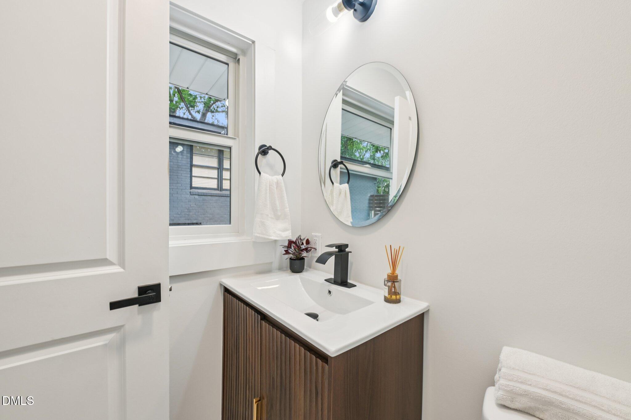 2708 Sarah Avenue Durham, NC 27707 - Photo 17 of 31 a bathroom with a sink a mirror and a toilet
