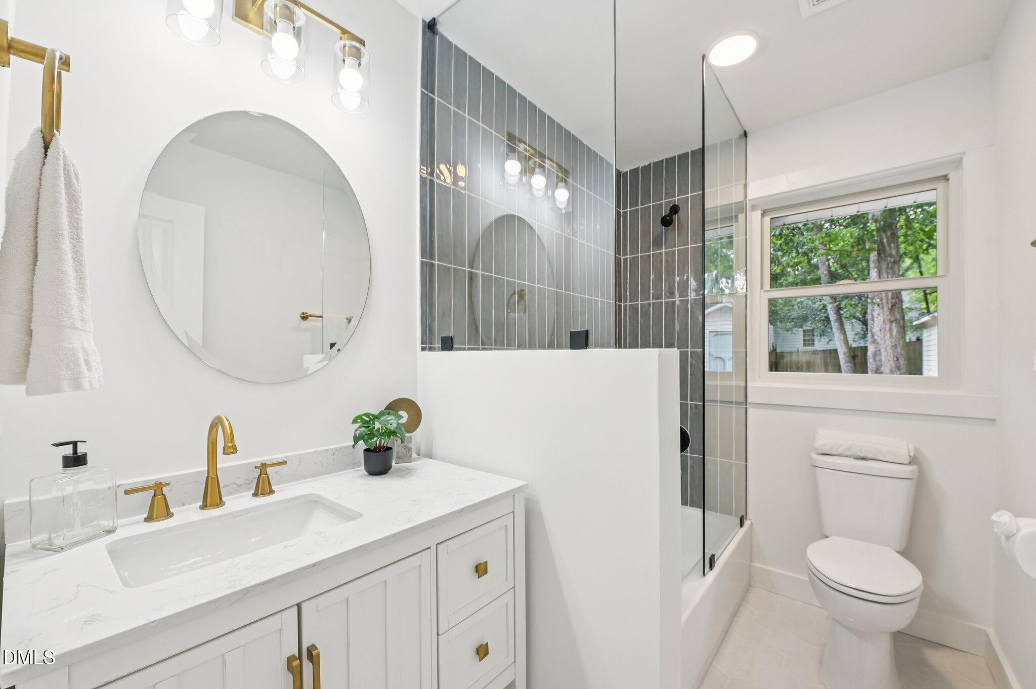2708 Sarah Avenue Durham, NC 27707 - Photo 23 of 31 a bathroom with a sink a toilet and a mirror