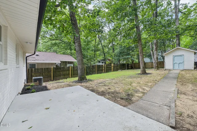 a backyard of a house with barbeque oven table and chairs
