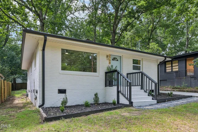 a view of a house with backyard and sitting area