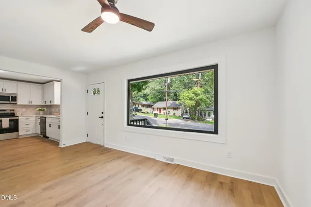 a view of a kitchen with wooden floor and a window