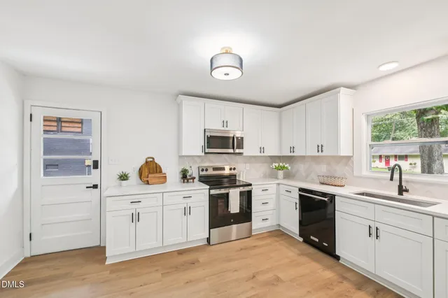 a kitchen with a stove sink and cabinets