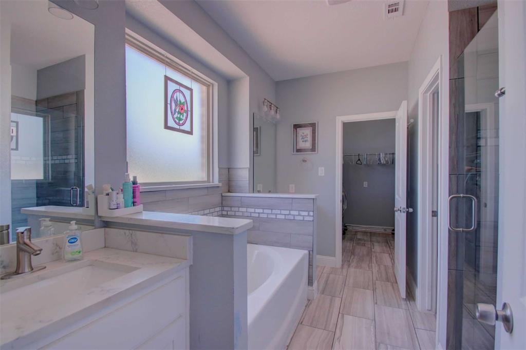 8789 Hutcheson Hill Road Springtown, TX 76082 - Photo 15 of 29 Primary bath with a spacious closet, a garden tub, double vanities, and a separate shower