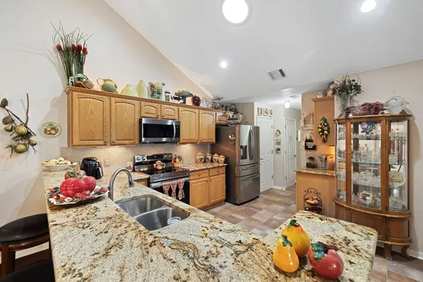 a kitchen that has a lot of cabinets a sink and a wooden floor