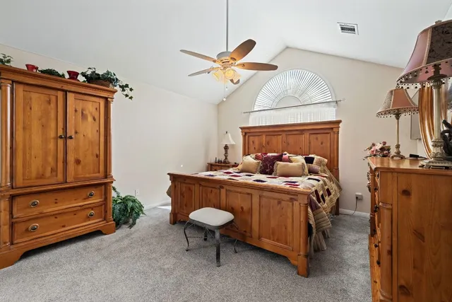 a bedroom with a bed a dresser and potted plants
