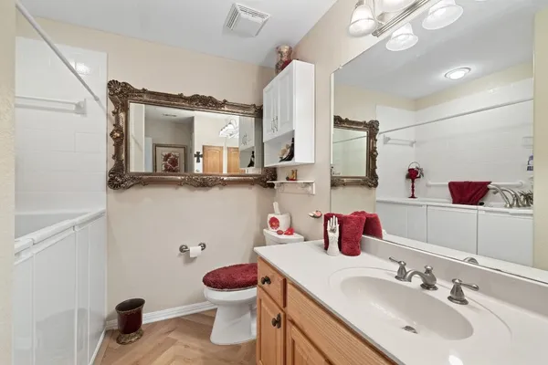 a bathroom with a sink vanity granite and toilet