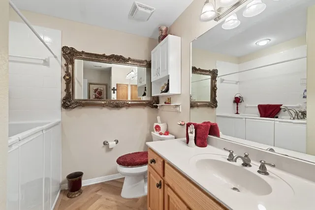 a bathroom with a sink vanity granite and toilet