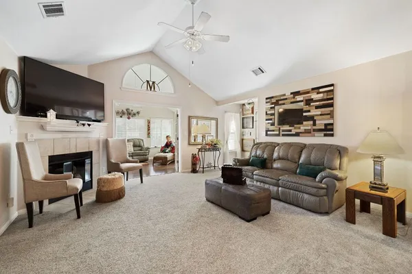 a living room with furniture a flat screen tv and a fireplace