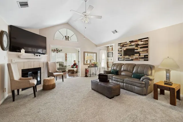 a living room with furniture a flat screen tv and a fireplace