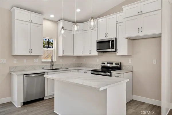 a kitchen with stainless steel appliances granite countertop a stove a sink and a microwave