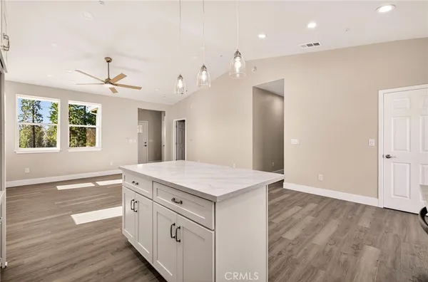 a view of a kitchen counter space a sink wooden floor and a window