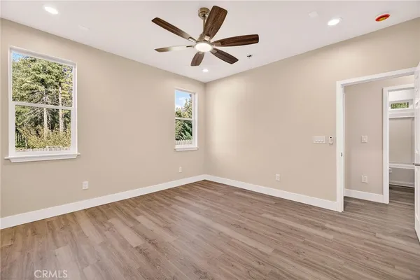 an empty room with wooden floor and windows