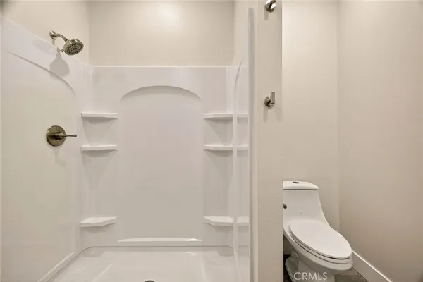 a bathroom with a toilet and a shower
