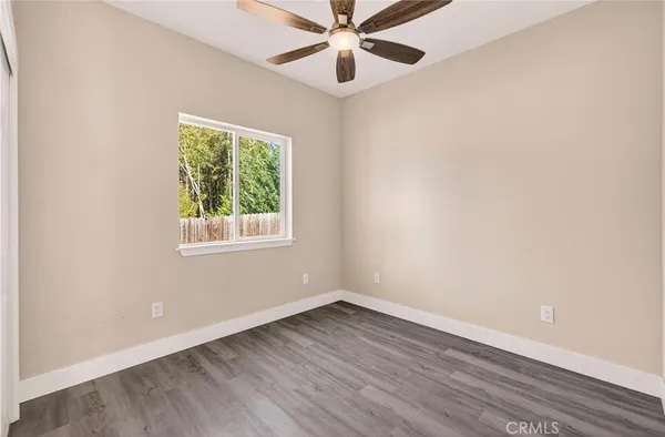 an empty room with a window and a ceiling fan
