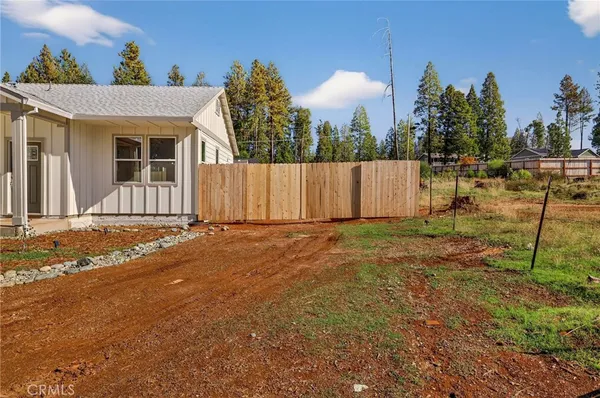a view of a house with backyard and a tree