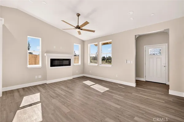 a view of an empty room with window and wooden floor
