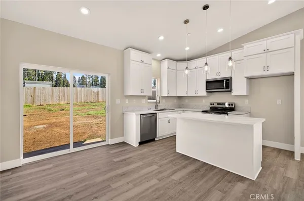 a kitchen with a refrigerator and a stove top oven