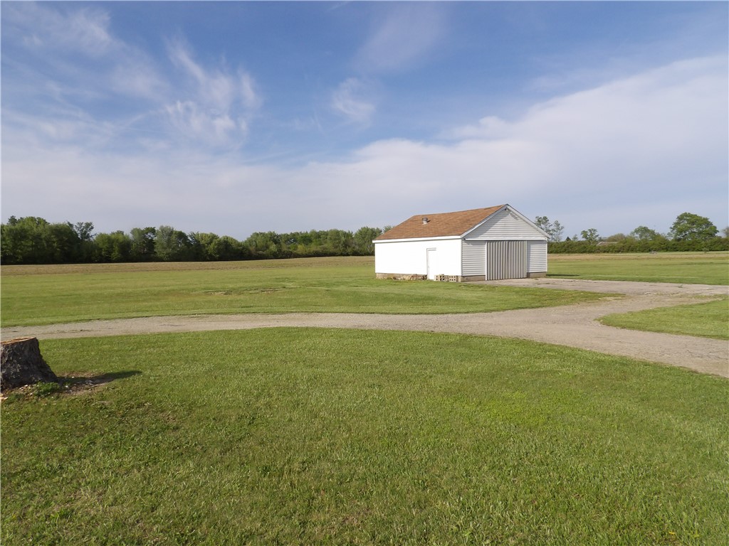 4505 North Alcony Conover Road Conover, OH 45317 - Photo 49 of 64 A quaint barn structure stands amidst lush green fields, bathed in natural sunlight.