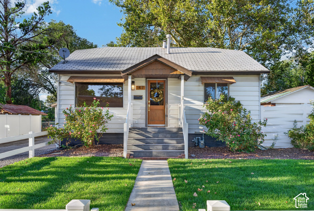 147 Center Street Clearfield, UT 84015 - Photo 51 of 55 White horizontal siding exterior with a peaked entry porch and a wood-panel front door