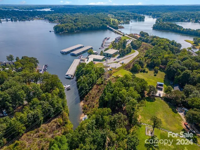 an aerial view of residential houses with outdoor space and lake view