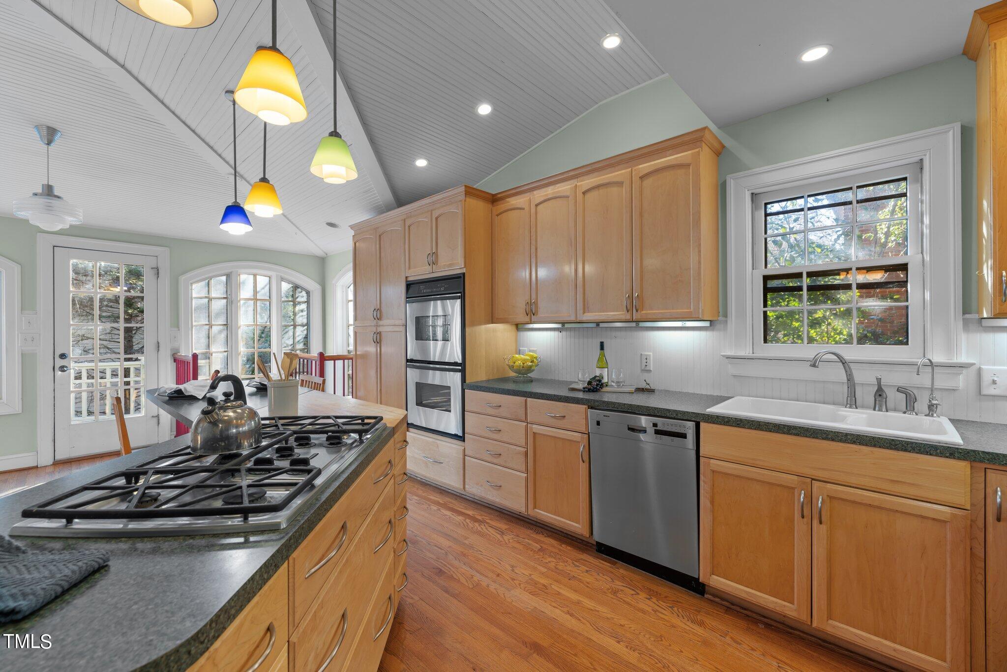 228 Furches Street Raleigh, NC 27607 - Photo 22 of 65 a kitchen with stainless steel appliances granite countertop a stove a sink and a refrigerator