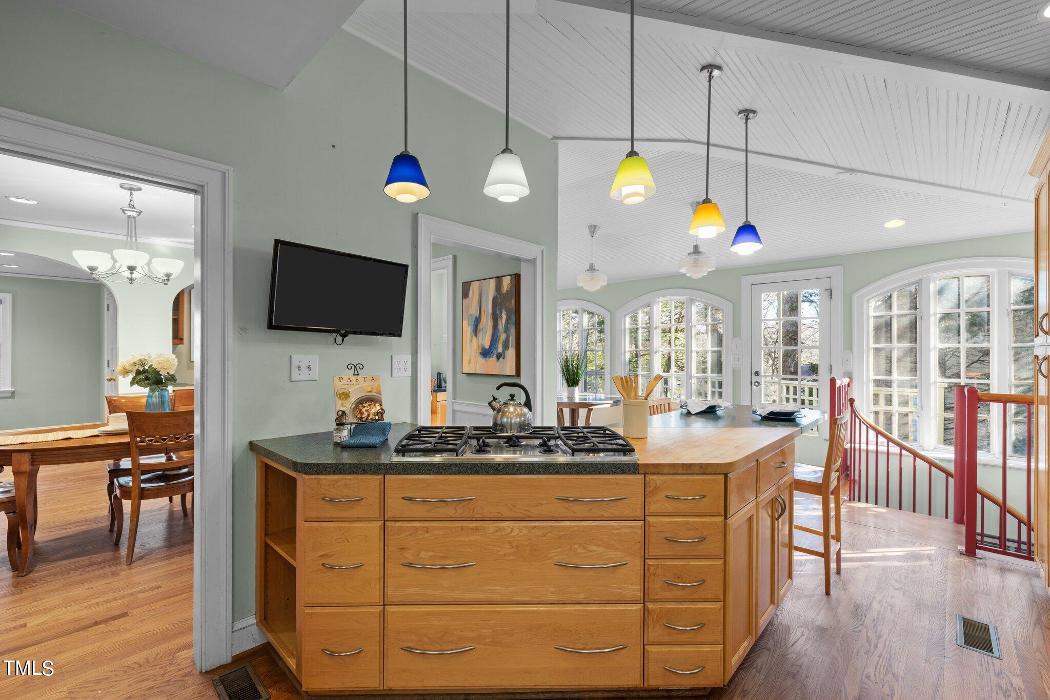 228 Furches Street Raleigh, NC 27607 - Photo 23 of 65 a kitchen with stainless steel appliances kitchen island granite countertop a sink cabinets and wooden floor