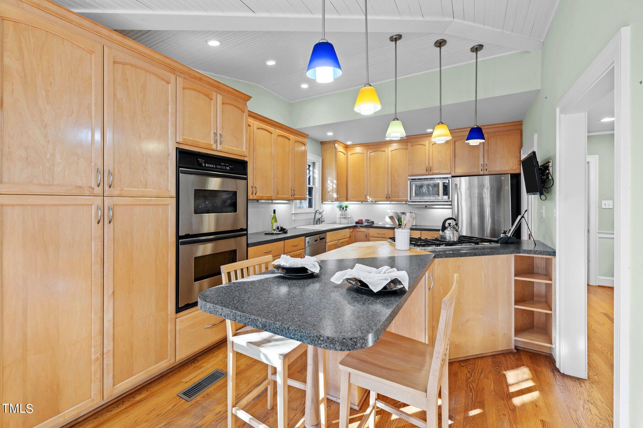 228 Furches Street Raleigh, NC 27607 - Photo 25 of 65 a kitchen with stainless steel appliances granite countertop a sink a stove and a refrigerator