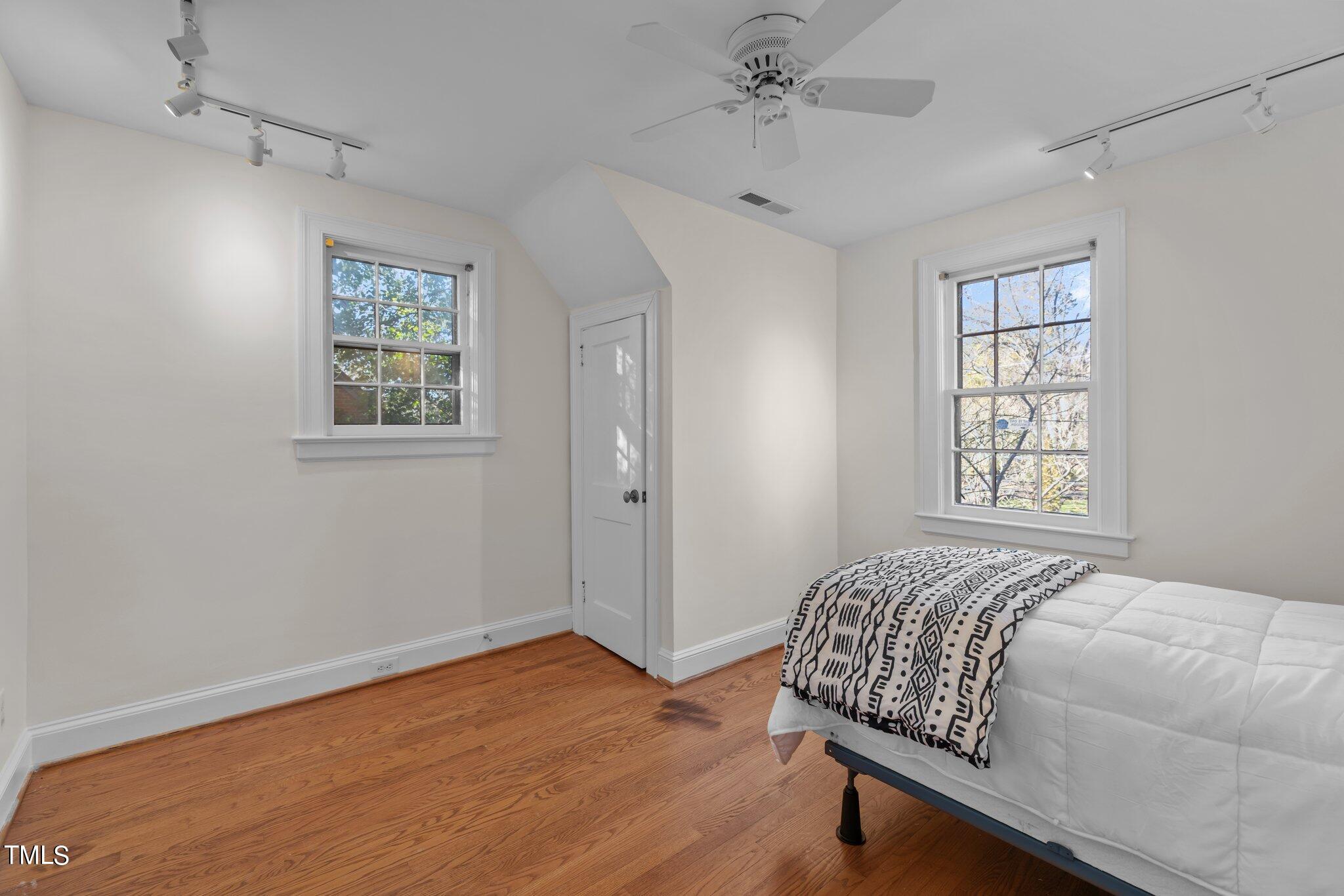 228 Furches Street Raleigh, NC 27607 - Photo 36 of 65 a bedroom with a bed and wooden floor