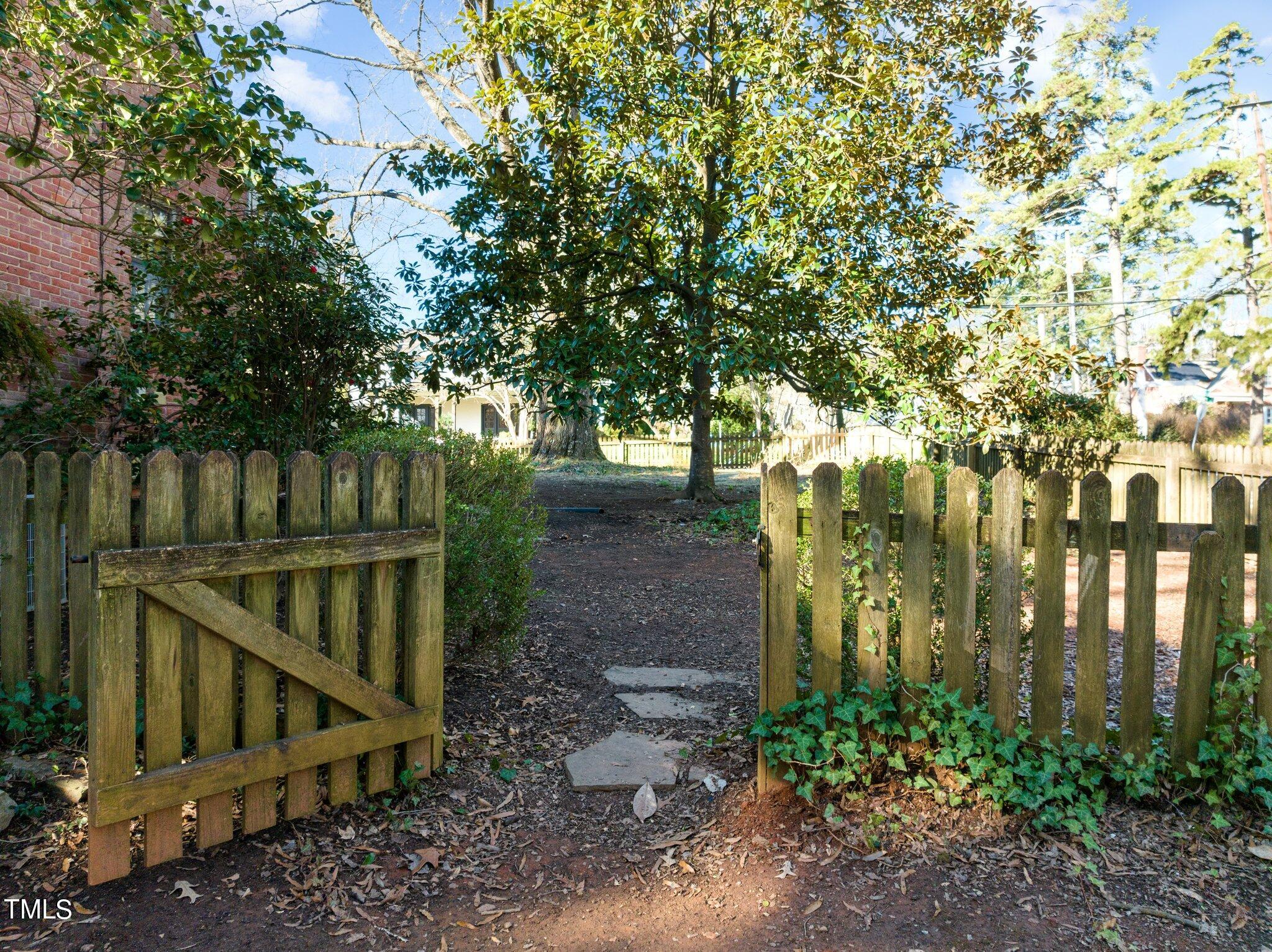 228 Furches Street Raleigh, NC 27607 - Photo 52 of 65 a view of small yard with large trees and wooden fence