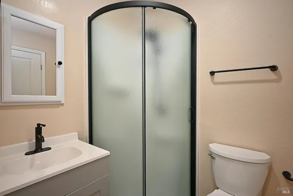 a bathroom with a toilet a sink and mirror