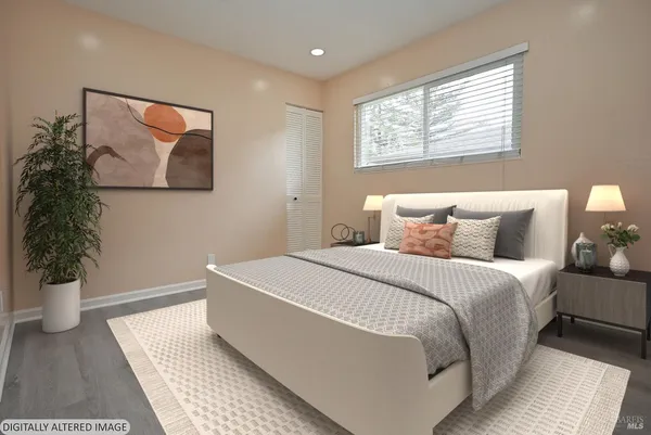 a bedroom with a large bed and a potted plant