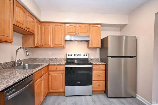 a kitchen with stainless steel appliances granite countertop a refrigerator stove and sink