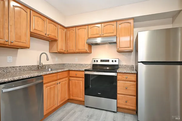 a kitchen with stainless steel appliances granite countertop a sink stove and refrigerator