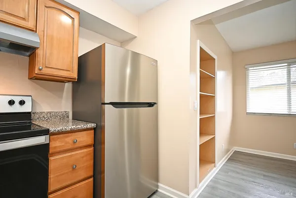 a kitchen with a refrigerator and a stove top oven
