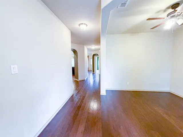 a view of a hallway with wooden floor
