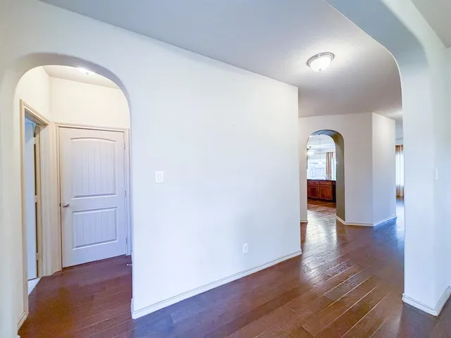 an empty room with wooden floor and mirror
