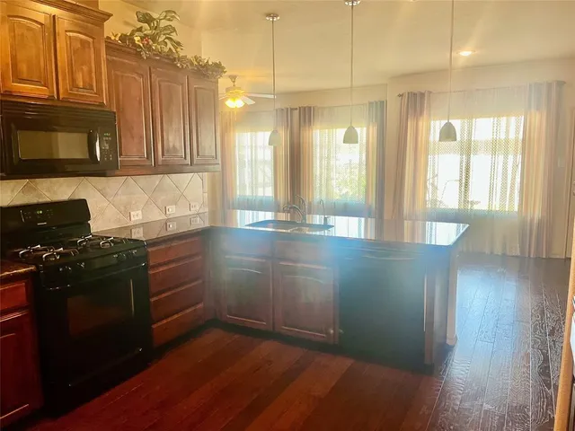 a kitchen with granite countertop a stove and a refrigerator