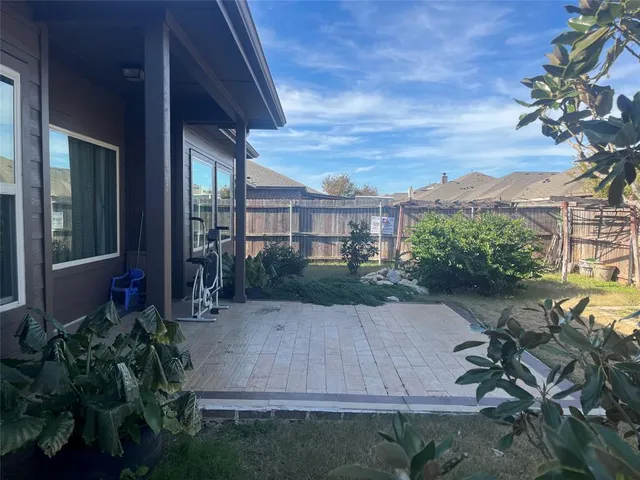 a view of backyard with potted plants and wooden fence