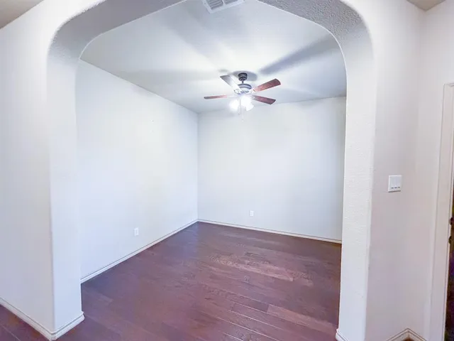 an empty room with a window and a fan