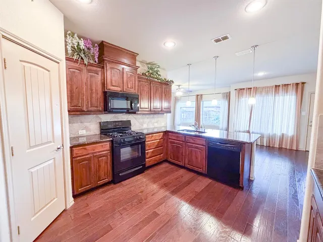 a kitchen with granite countertop stainless steel appliances and wooden cabinets