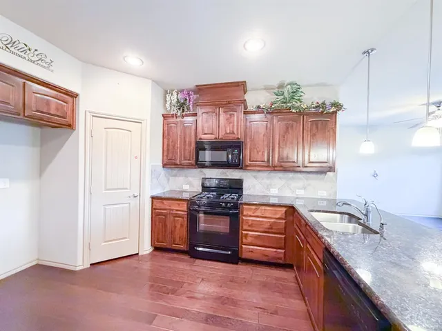 a view of kitchen with granite countertop cabinets and wooden floor