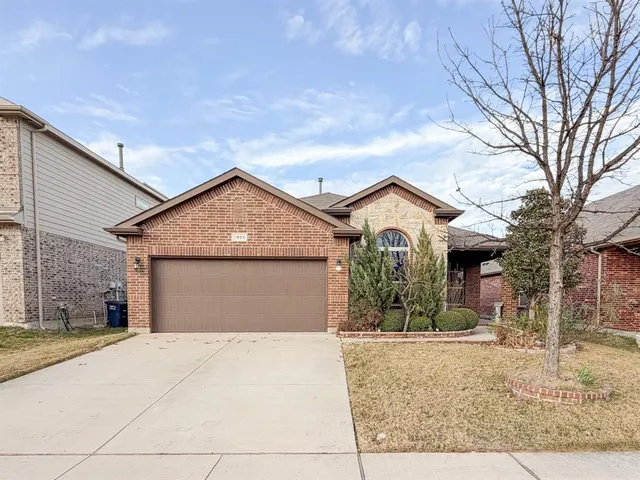 a view of a house with a yard and large tree