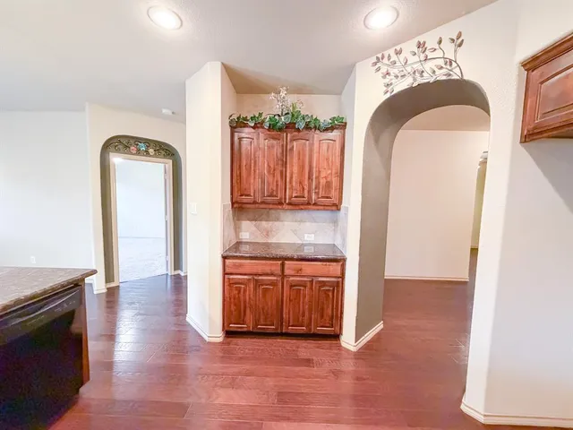 a kitchen with stainless steel appliances granite countertop a sink a stove and a wooden floors