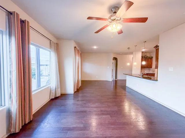 a view of a livingroom with wooden floor and a ceiling fan