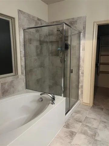 a spacious bathroom with a bathtub and a shower