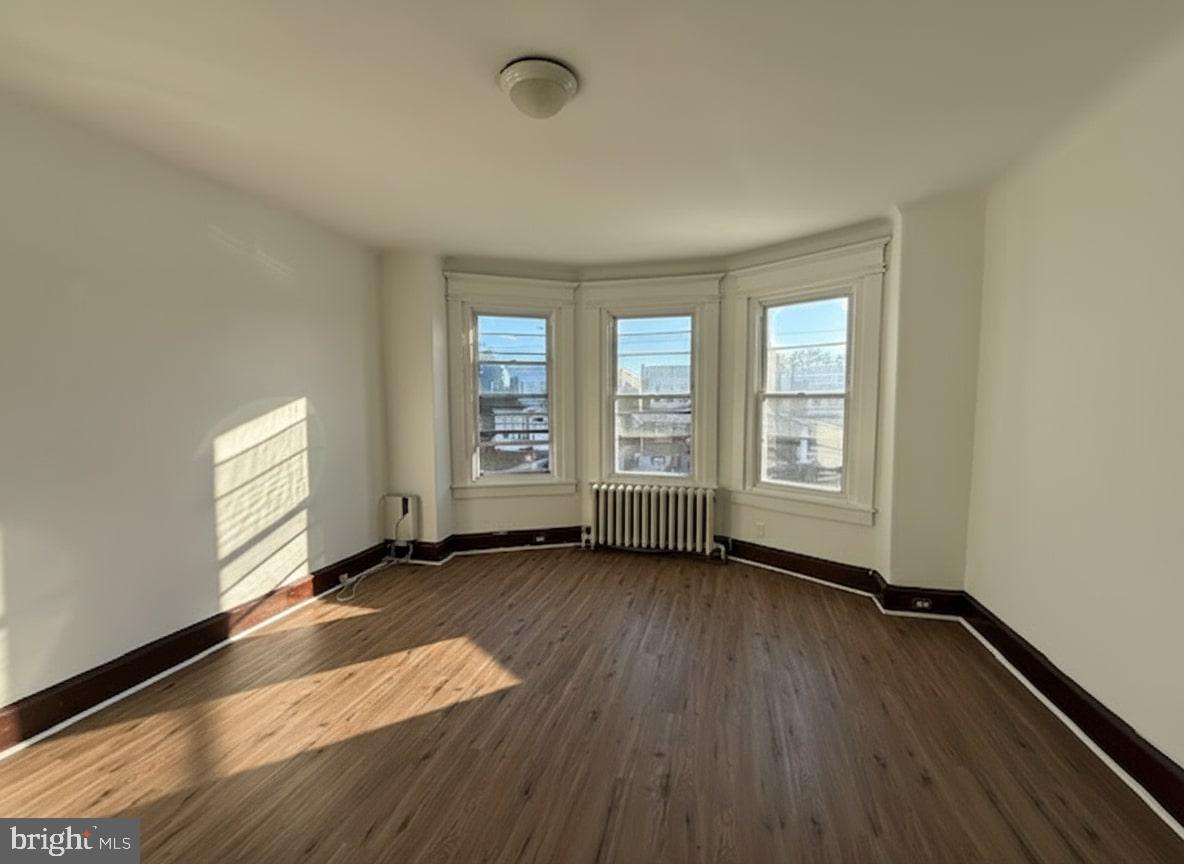 605 West Olney Avenue, Unit 2 Philadelphia, PA 19120 - Photo 1 of 11 an empty room with wooden floor and windows