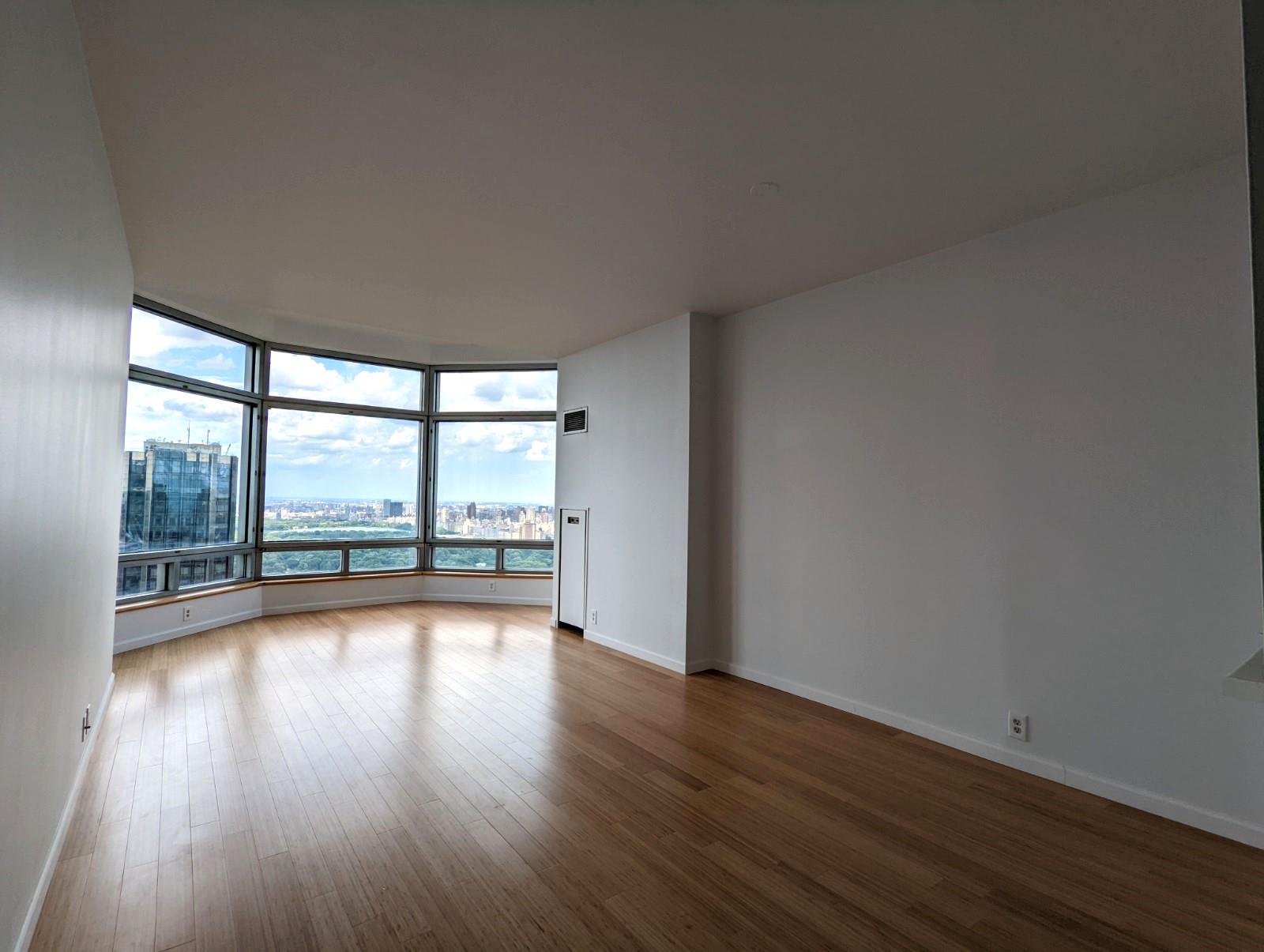 a view of a room with wooden floor and floor to ceiling window